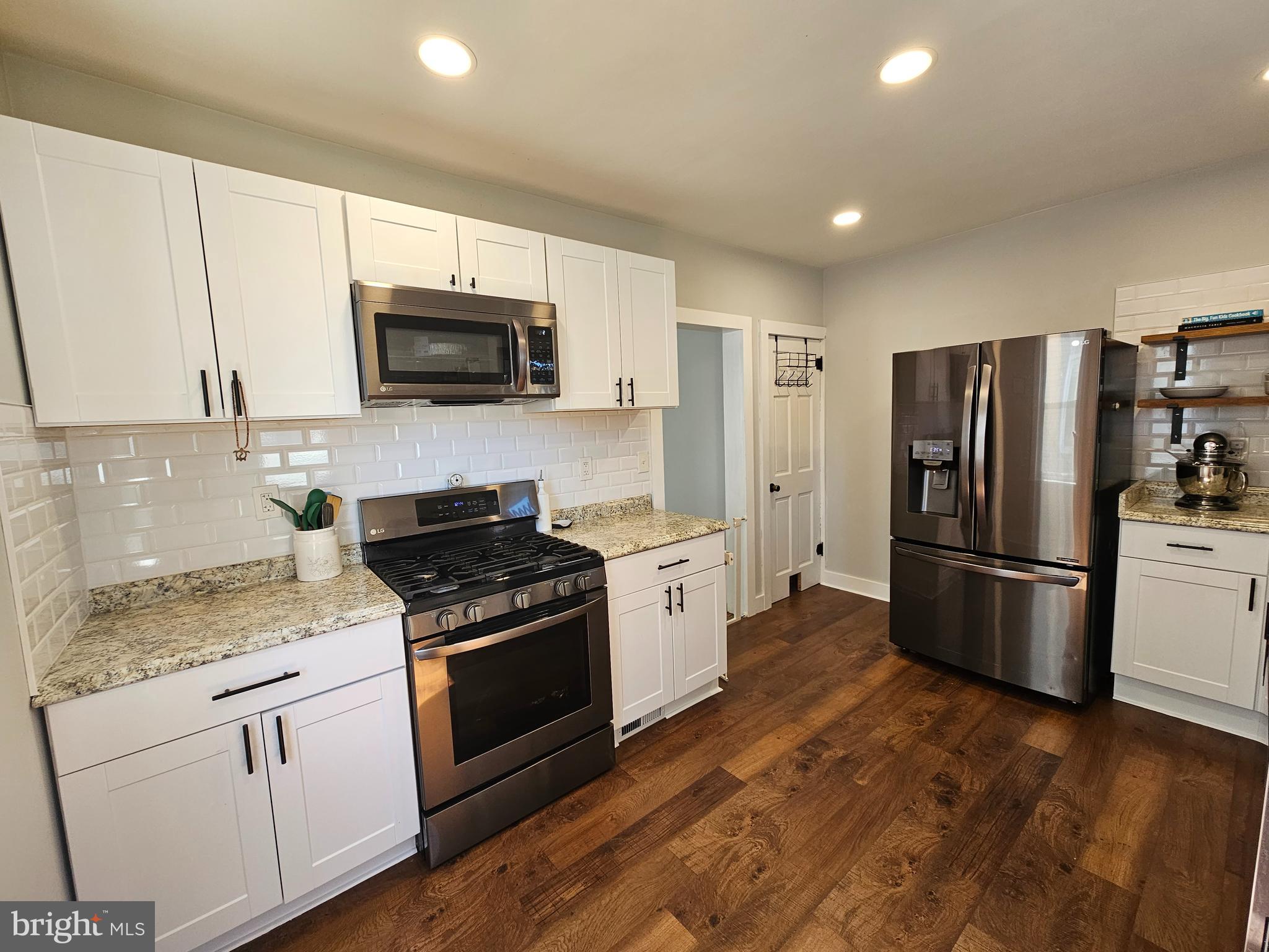 303 Delaware Avenue Riverside, NJ 08075 - Photo 8 of 30 a kitchen with a sink a stove a refrigerator and white cabinets