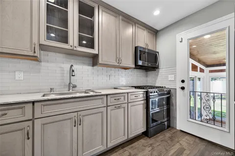 a kitchen with stainless steel appliances granite countertop a stove microwave and cabinets