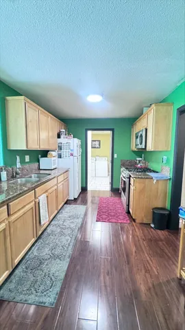 a kitchen with stainless steel appliances granite countertop a sink and a wooden floors