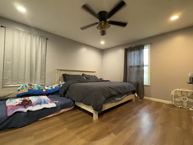 a bedroom with a bed window and a chandelier