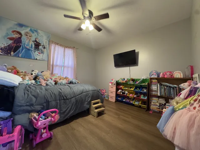 a bedroom with furniture and a flat screen tv
