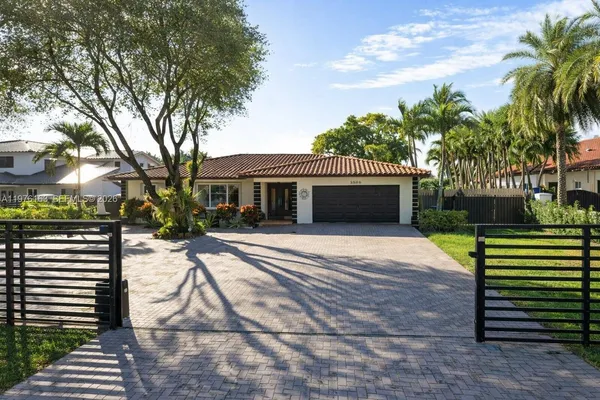 a front view of a house with a yard and potted plants