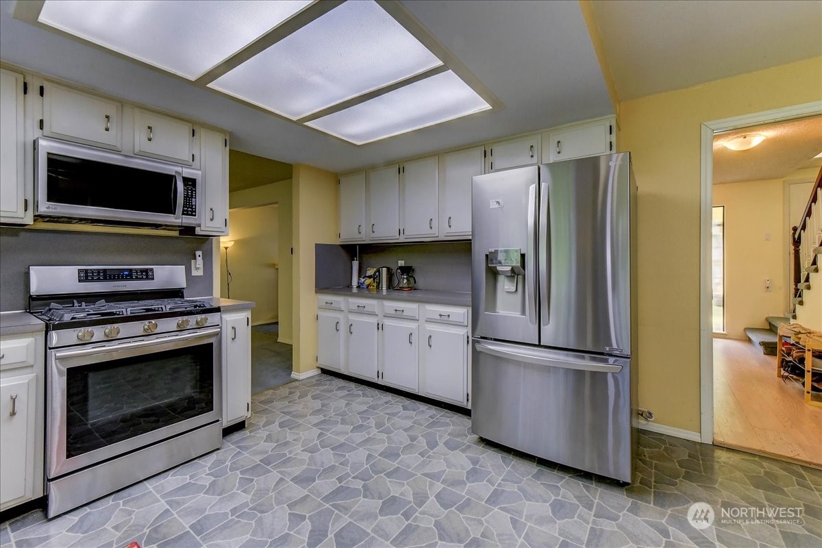 10451 Northeast 204th Place Bothell, WA 98011 - Photo 12 of 40 a kitchen with stainless steel appliances granite countertop a refrigerator stove and microwave