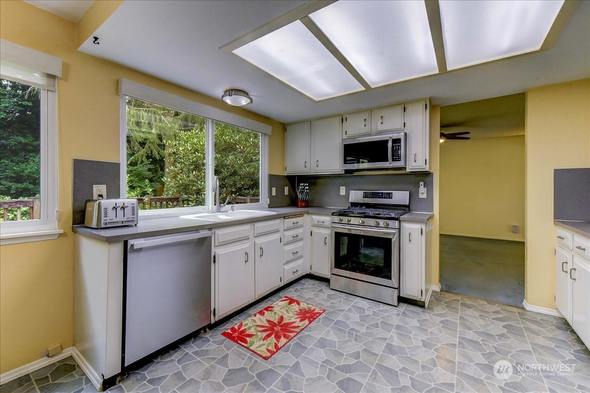 10451 Northeast 204th Place Bothell, WA 98011 - Photo 13 of 40 a kitchen with a stove a sink and a microwave