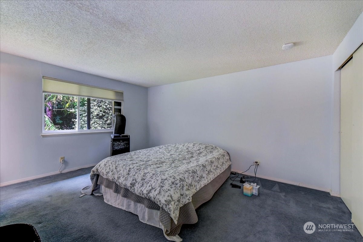 10451 Northeast 204th Place Bothell, WA 98011 - Photo 19 of 40 a bedroom with a bed and a window