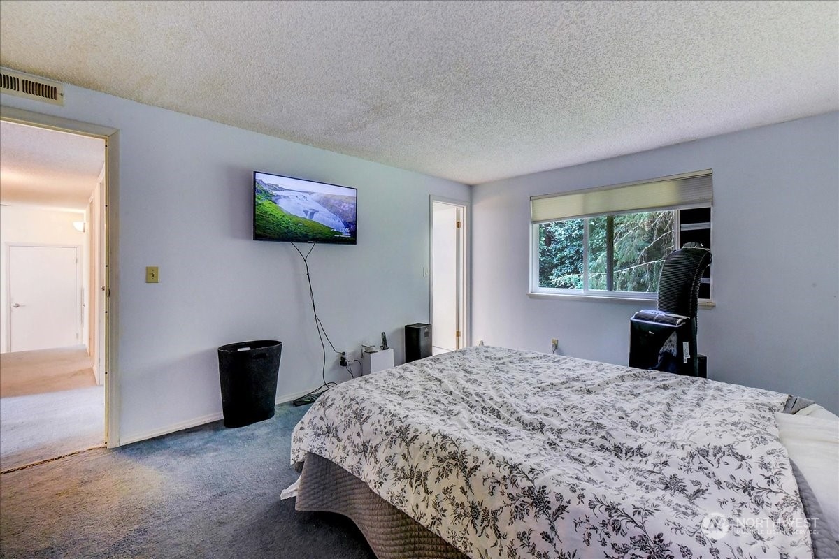 10451 Northeast 204th Place Bothell, WA 98011 - Photo 21 of 40 a bedroom with a bed and a flat screen tv