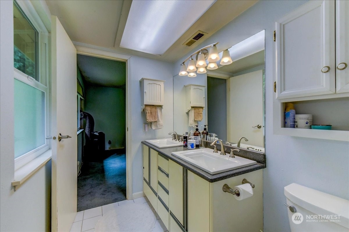 10451 Northeast 204th Place Bothell, WA 98011 - Photo 23 of 40 a bathroom with a sink toilet and mirror