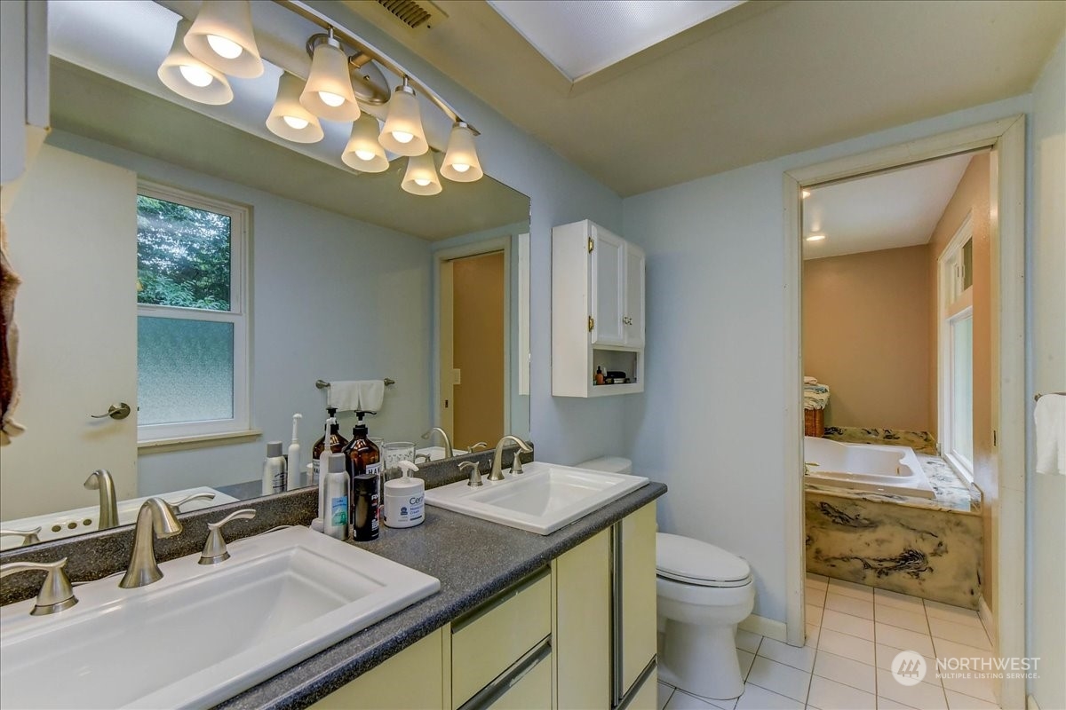 10451 Northeast 204th Place Bothell, WA 98011 - Photo 24 of 40 a bathroom with a sink a toilet and a mirror