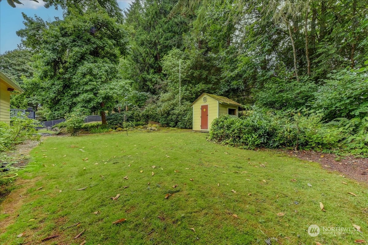 10451 Northeast 204th Place Bothell, WA 98011 - Photo 36 of 40 a yellow house with lots of trees in the background