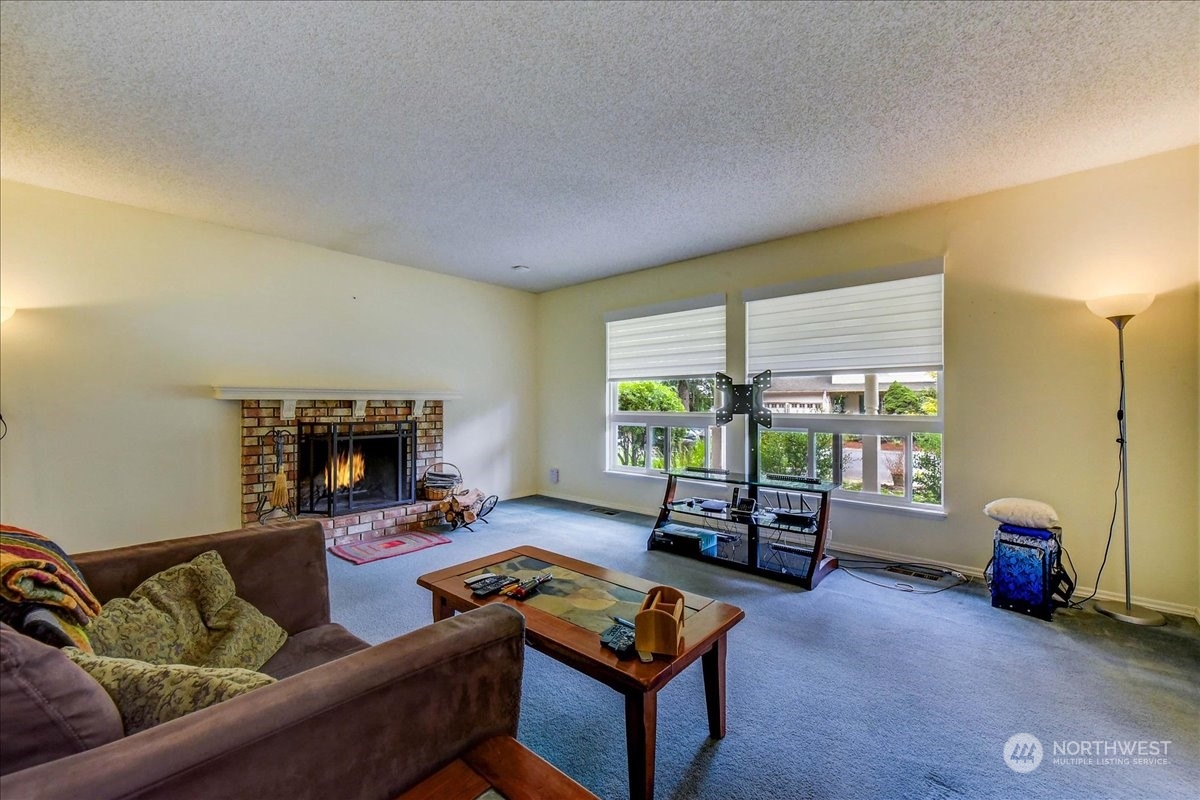 10451 Northeast 204th Place Bothell, WA 98011 - Photo 7 of 40 a living room with furniture and a fireplace