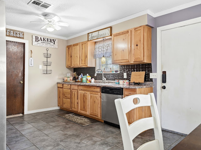 30063 South 4300th Road Stigler, OK 74462 - Photo 13 of 58 Kitchen featuring wood-finish cabinetry, dark tile backsplash, stainless steel dishwasher, and tile flooring