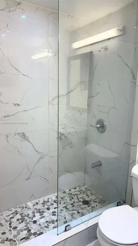 a bathroom with a toilet and a shower