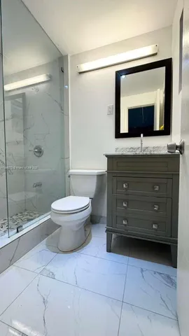 a bathroom with a toilet a sink and a mirror