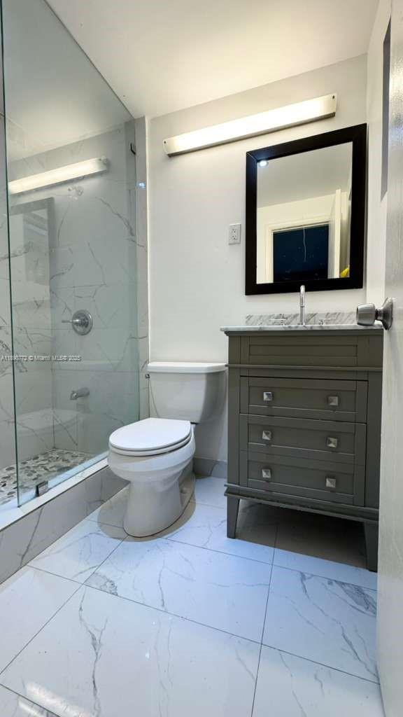 346 86th Street, Unit 2 Miami Beach, FL 33141 - Photo 12 of 13 a bathroom with a toilet a sink and a mirror