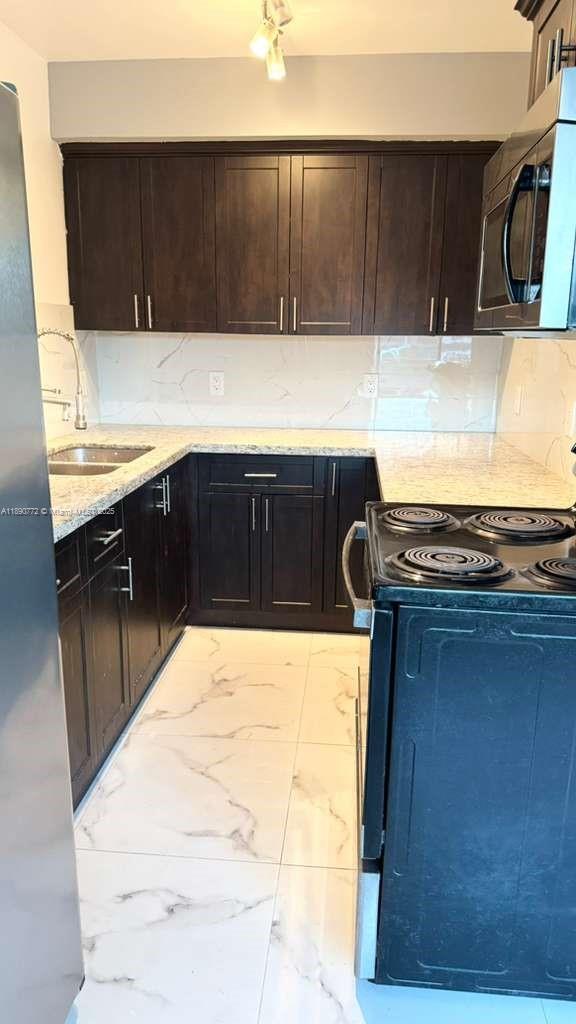 346 86th Street, Unit 2 Miami Beach, FL 33141 - Photo 2 of 13 a kitchen with a sink and a stove
