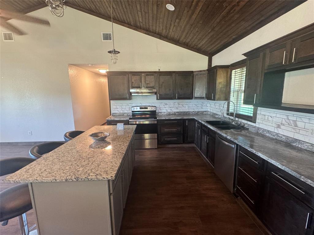 377 Private Road 3249, Unit ARENA Decatur, TX 76234 - Photo 27 of 40 a kitchen with granite countertop a sink a counter top space and stainless steel appliances