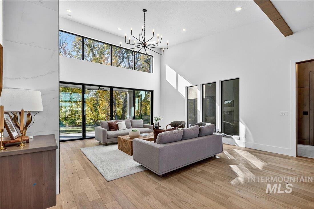 665 Watkins Street Middleton, ID 83644 - Photo 14 of 34 Living room featuring light wood-style floors, recessed lighting, a chandelier, a towering ceiling, and beamed ceiling