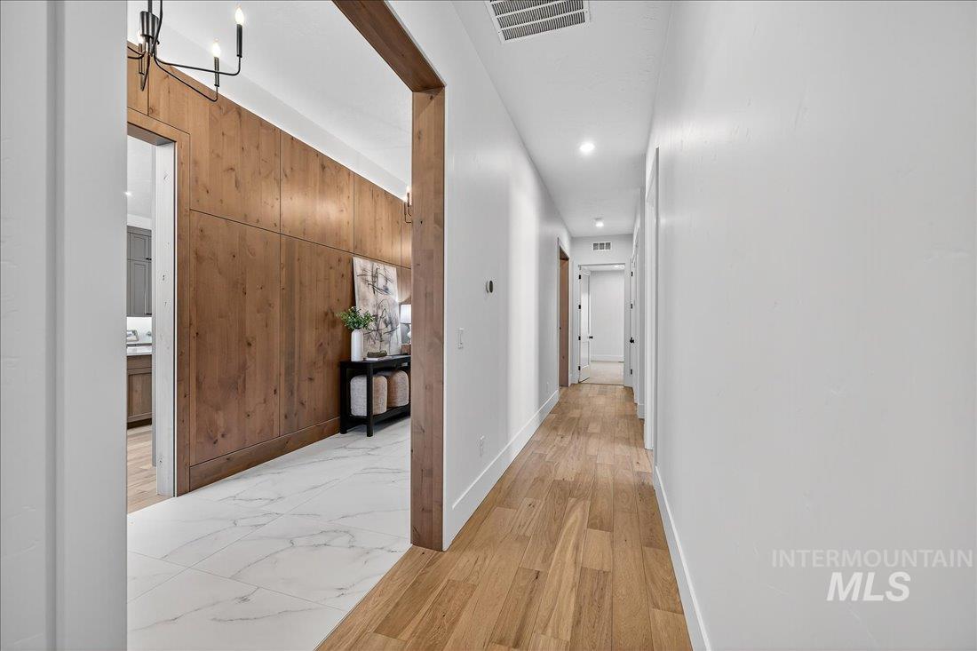 665 Watkins Street Middleton, ID 83644 - Photo 17 of 34 Hall with wooden walls, light wood finished floors, a chandelier, and recessed lighting