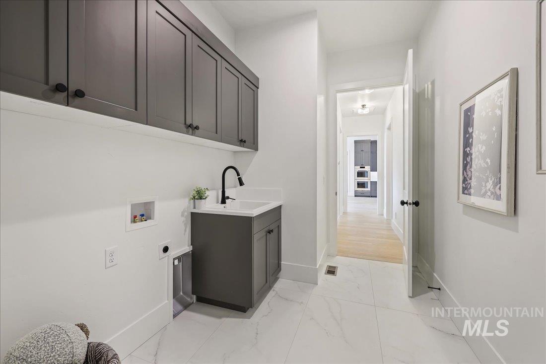 665 Watkins Street Middleton, ID 83644 - Photo 29 of 34 Laundry room with electric dryer hookup, light marble finish flooring, hookup for a washing machine, and cabinet space