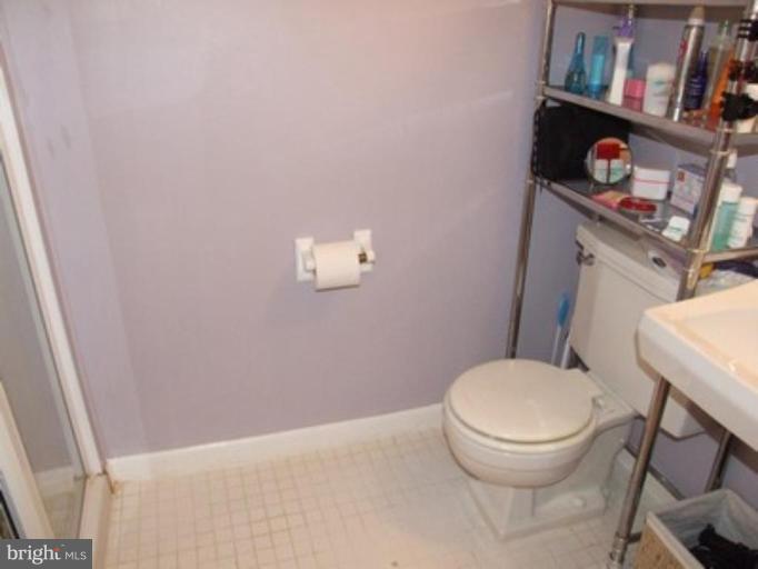 3719 Astoria Road Kensington, MD 20895 - Photo 12 of 19 a white toilet sitting next to a bathroom sink and vanity