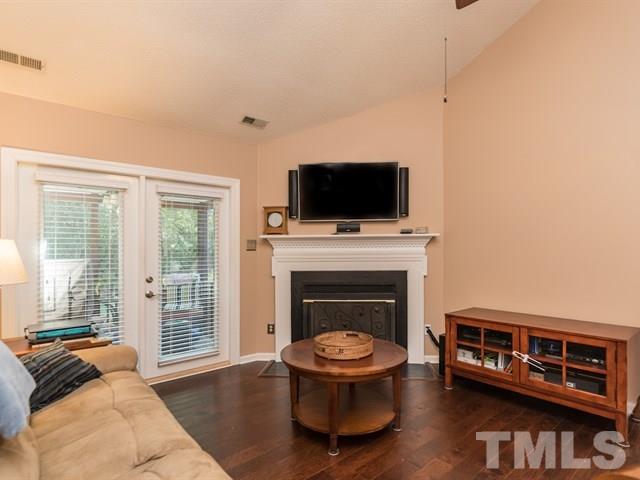 12204 Inglehurst Drive Raleigh, NC 27613 - Photo 8 of 14 a living room with a fireplace and a flat screen tv