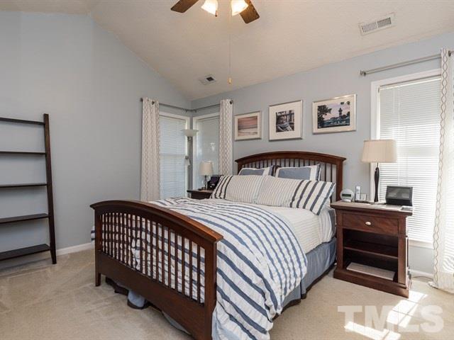 12204 Inglehurst Drive Raleigh, NC 27613 - Photo 9 of 14 a bedroom with a bed and a chandelier