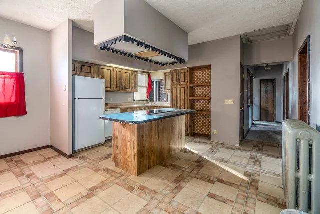 a kitchen with stainless steel appliances granite countertop a refrigerator and a stove