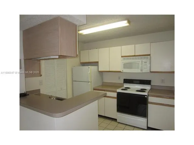 a kitchen with a stove a refrigerator and cabinets