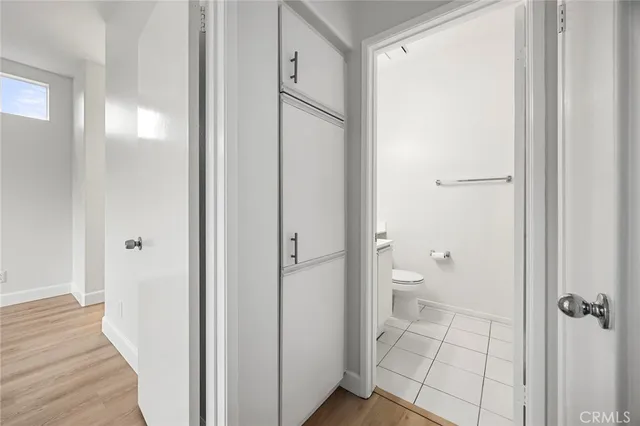 an empty room with wooden floor ceiling fan and windows