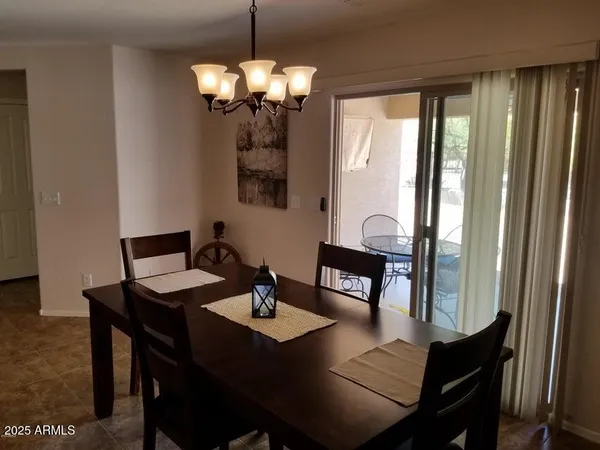a patio with table and chairs and potted plants