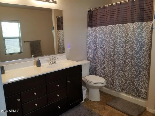 a bedroom with a bed and a flat tv screen on dresser