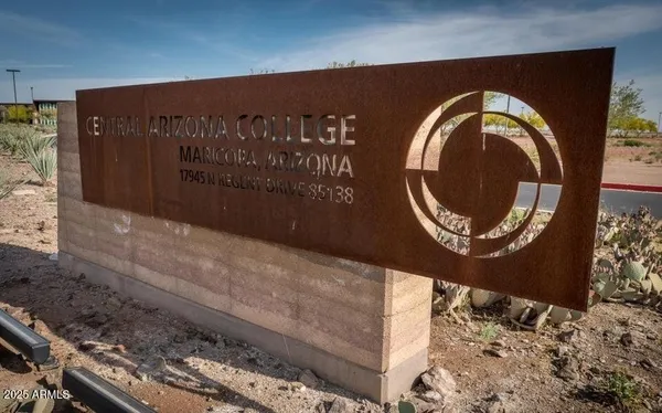 a view of a park with lawn chairs under an umbrella