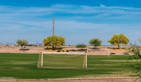 a view of a big yard with table and chairs under an umbrella