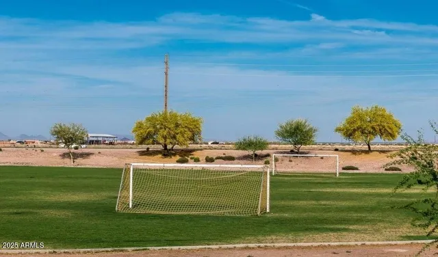 a view of a big yard with table and chairs under an umbrella