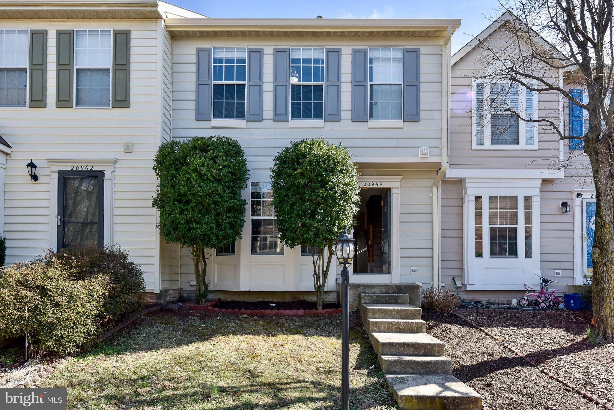 20964 Rootstown Terrace Ashburn, VA 20147 - Photo 1 of 24 a front view of a house with a yard