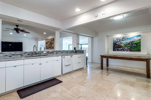 a large living room with stainless steel appliances kitchen island granite countertop furniture and a flat screen tv