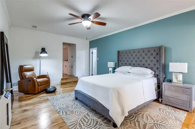 a spacious bedroom with a bed and lamp chandelier