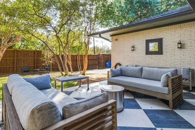 a view of a patio with couches and a table and chairs with wooden floor