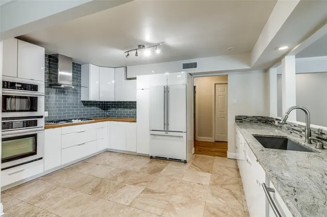 a large kitchen with a refrigerator sink and cabinets