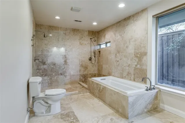 a spacious bathroom with a granite countertop tub toilet and a shower