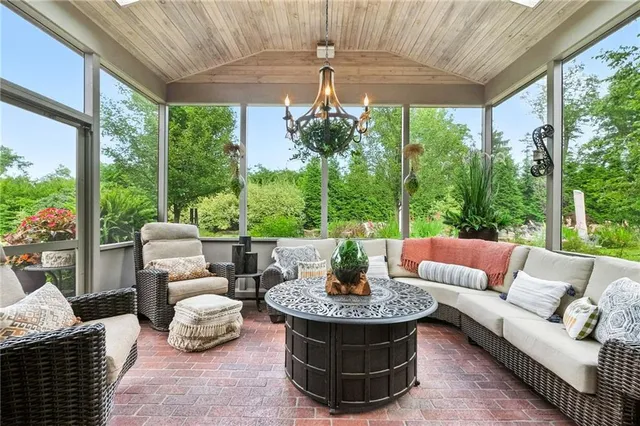 a living room with patio furniture and a potted plant