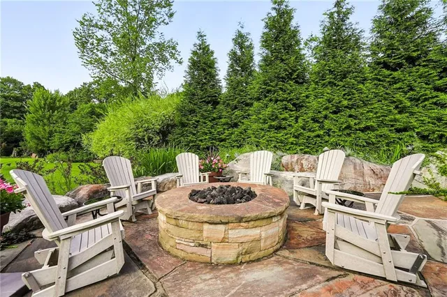 a view of a patio with a dining table and chairs with a small yard