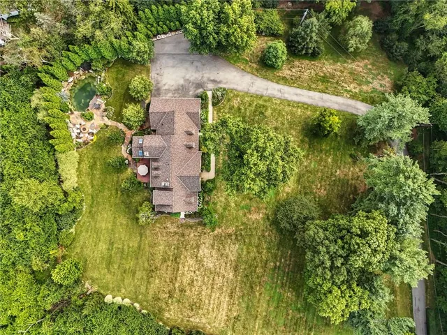 an aerial view of residential houses with outdoor space and trees