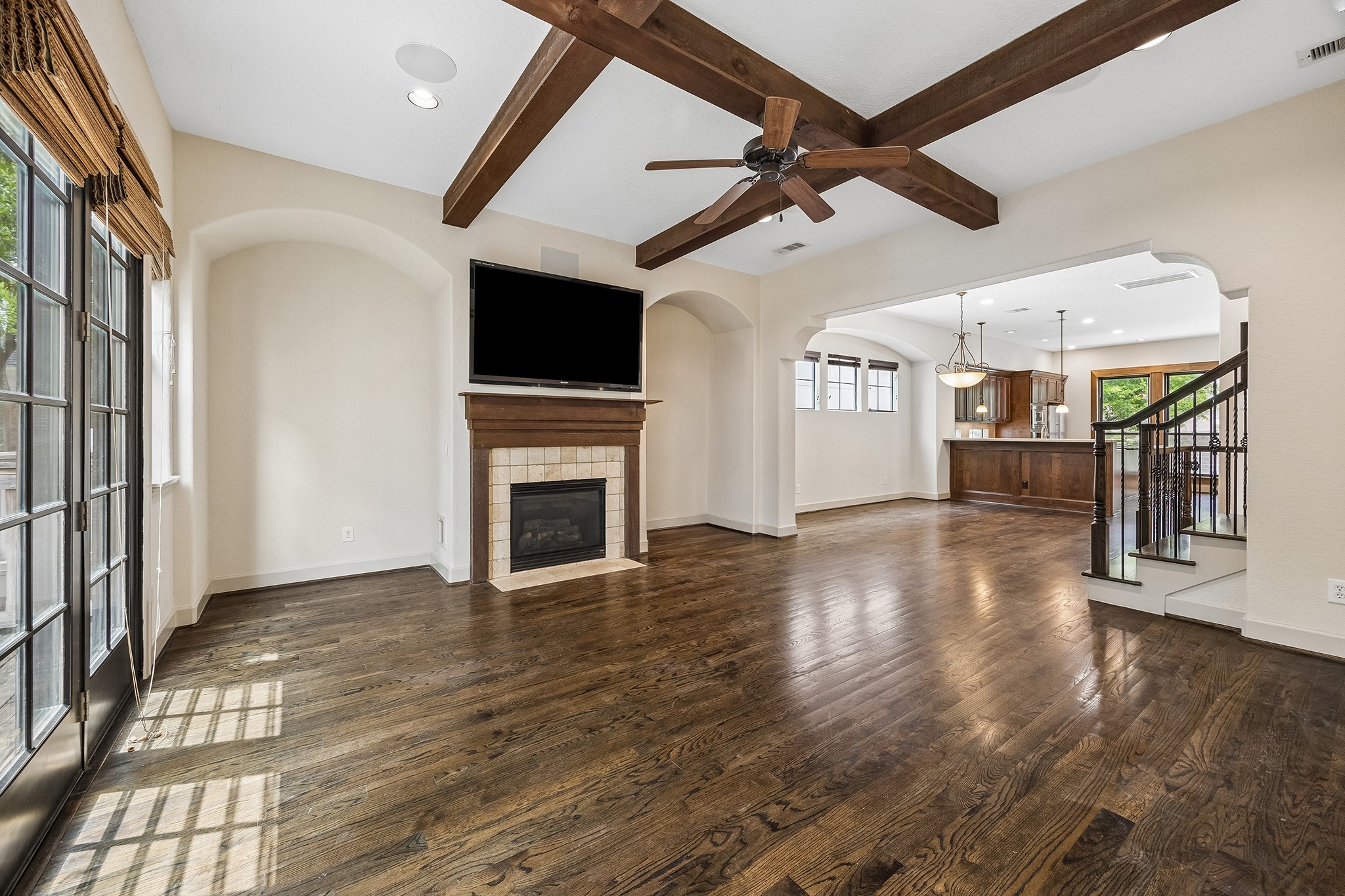 4301 Gibson Street Houston, TX 77007 - Photo 7 of 24 Second floor living room featuring a gas log fireplace, high ceilings, wood beams and French doors looking to private balcony.