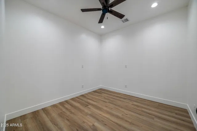 an empty room with a ceiling fan and carpet