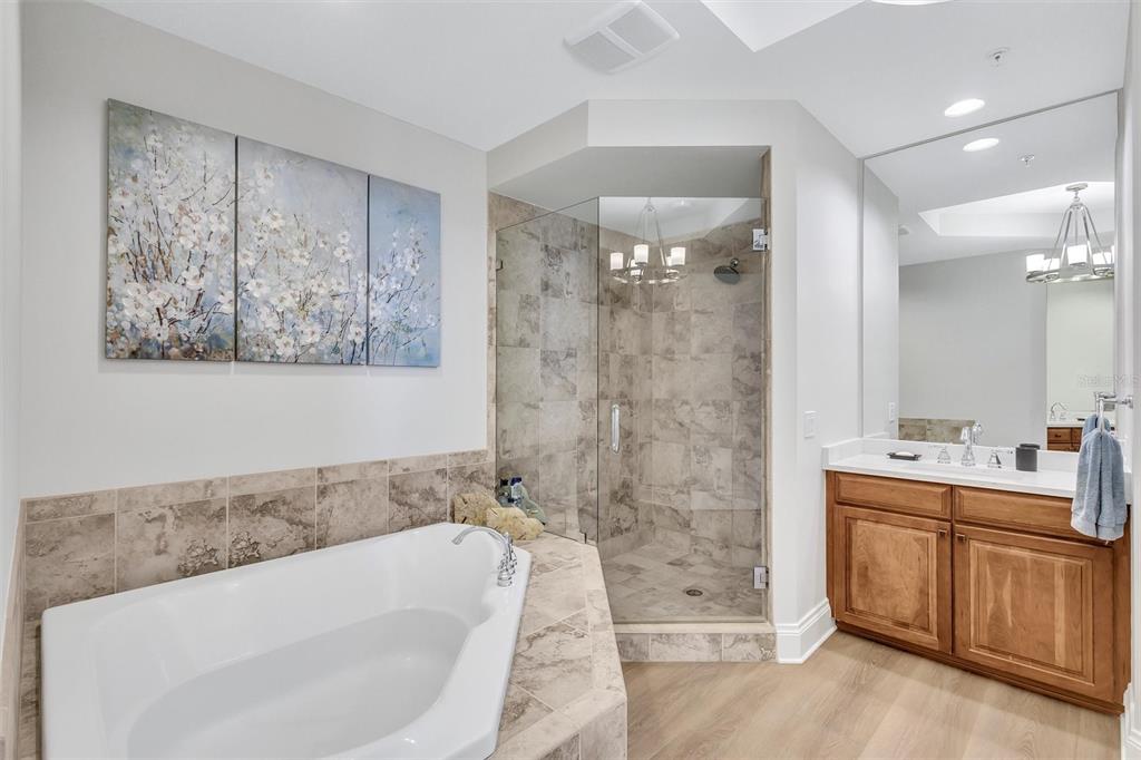 140 Riviera Dunes Way, Unit 1203 Palmetto, FL 34221 - Photo 16 of 30 a bathroom with a tub a sink and glass door shower