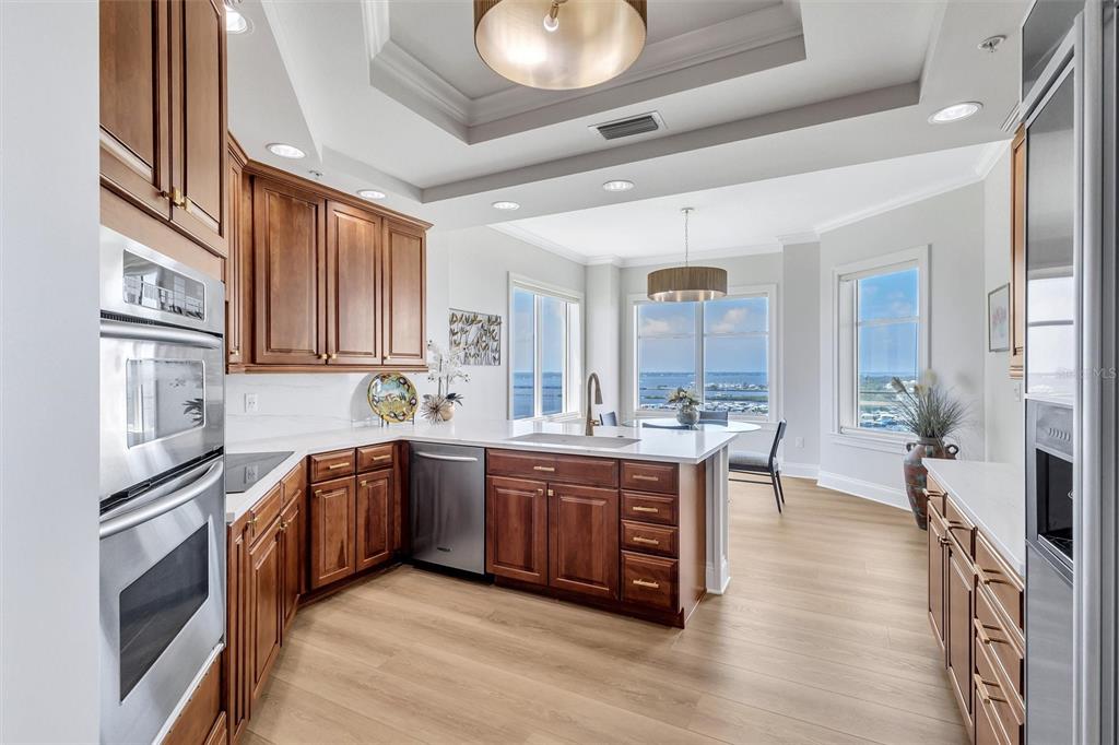 140 Riviera Dunes Way, Unit 1203 Palmetto, FL 34221 - Photo 5 of 30 a large kitchen with stainless steel appliances granite countertop a lot of counter space and wooden floor