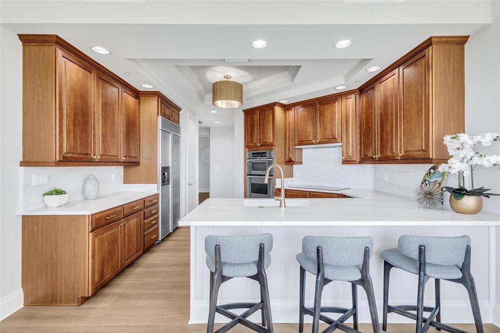 140 Riviera Dunes Way, Unit 1203 Palmetto, FL 34221 - Photo 6 of 30 a kitchen with stainless steel appliances granite countertop a table chairs sink and cabinets