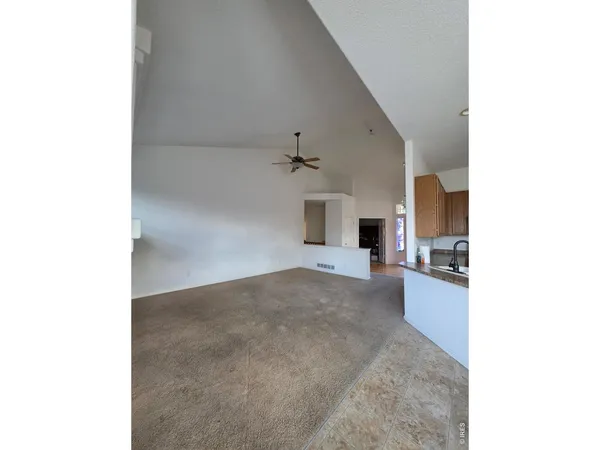 a view of a living room with furniture and a ceiling fan