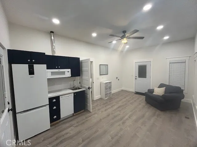 a kitchen with stainless steel appliances granite countertop a refrigerator a sink dishwasher and a stove with wooden floor